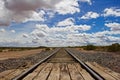 Train Tracks to Horizon with Fluffy Clouds Royalty Free Stock Photo