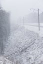 Train tracks in winter, snowing. Slope and fallen tree Royalty Free Stock Photo