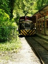 A train traveling down train tracks near a forest