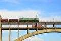 Train and a truck traveling on the bridge against the sky