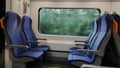 Train window with blurred landscape and empty seats. Royalty Free Stock Photo