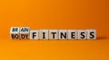 Train your brain. Turned a cube and changed words `body fitness` to `brain fitness` on wooden cubes. Beautiful orange backgrou