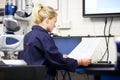 Trainee Engineer Studying Plans With CMM Arm In Foreground