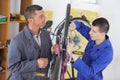 Trainee mechanic being supervised working on bicycle in workshop Royalty Free Stock Photo