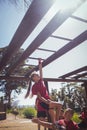 Trainer assisting girl to climb monkey bars during obstacle course training Royalty Free Stock Photo