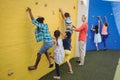 Trainer assisting kids in climbing wall Royalty Free Stock Photo
