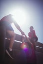 Trainer assisting kids to climb a wooden wall during obstacle course training Royalty Free Stock Photo