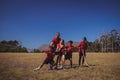 Trainer assisting kids in tug of war during obstacle course training Royalty Free Stock Photo