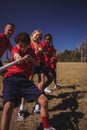 Trainer assisting kids in tug of war during obstacle course training Royalty Free Stock Photo