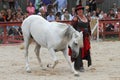 A trainer dressed as medieval lady demonstrates horse skills