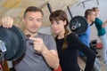 Trainer explaining how to use training machine in gym Royalty Free Stock Photo
