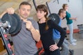 Trainer explaining how to use training machine in gym Royalty Free Stock Photo
