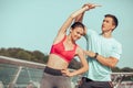 Trainer and female athlete exercising on the city bridge