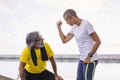 trainer giving encouragement to senior sports man