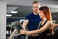 Trainer help woman with gym sports machine Royalty Free Stock Photo