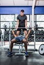 Trainer helping muscular man lifting barebell Royalty Free Stock Photo