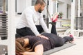 Trainer helping woman with leg muscles workout