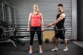 Trainer helping woman with lifting barbell Royalty Free Stock Photo