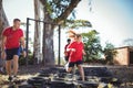 Trainer instructing kids during tyres obstacle course training