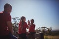 Trainer looking at girls giving high five to each other during obstacle course training Royalty Free Stock Photo