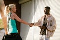 Trainer and mature woman smiling and shaking hands before workout Royalty Free Stock Photo