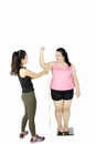 Trainer measuring bicep of fat woman