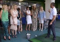 Trainer standing with a golf club in hands teaching women golfing