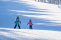 A trainer teaches a child to ski