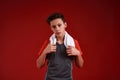 A Trainer. A teenage boy is engaged in sport, he is looking at camera while holding white towel. Isolated on red Royalty Free Stock Photo