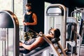 Trainer wearing a face mask helps a young man do his workout at the gym Royalty Free Stock Photo