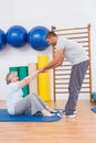 Trainer working with senior woman on exercise mat Royalty Free Stock Photo