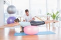 Trainer working with woman on exercise ball Royalty Free Stock Photo