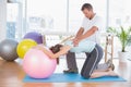 Trainer working with woman on exercise ball Royalty Free Stock Photo