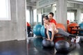 Trainers are teaching to push. Woman doing push ups while trainer correcting position. Male personal trainer teaching to female i