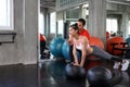 Trainers are teaching to push. Woman doing push ups while trainer correcting position. Male personal trainer teaching to female i