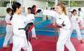 Trainier teaching girl jabbing during karate training