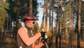 Training an athlete on the roller skaters. Biathlon ride on the roller skis with ski poles, in the helmet. Autumn