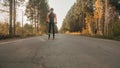 Training an athlete on the roller skaters. Biathlon ride on the roller skis with ski poles, in the helmet. Autumn