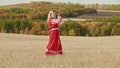 Training in the autumn field - a belligerent woman wields with a sword - looking in the camera