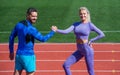 training with coach. fitness partners. athletic man and woman compete in armwrestling. male and female coach on stadium Royalty Free Stock Photo