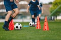 Training with cones. Training football session for children on soccer camp. Boy in children`s soccer team on training