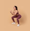 Smiling Young Woman Doing Deep Squat Exercise