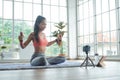 Young asian woman exercise with dumbbell while online tutorial on mobile phone Royalty Free Stock Photo