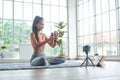 Young asian woman exercise with dumbbell while online tutorial on mobile phone Royalty Free Stock Photo