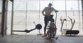 Training with intense cardio bike, exercise in closed gym. Men doing difficult cardio workout with airbike