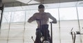 Training with intense cardio bike, exercise in closed gym. Men doing difficult cardio workout with airbike