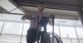 Training with intense cardio bike, exercise in closed gym. Men doing difficult cardio workout with airbike