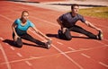 Training, legs and couple stretching in stadium for race, marathon or competition for health. Sports, fitness and runner Royalty Free Stock Photo
