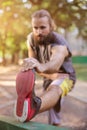 Training outdoors. Young man stretching his legs. Royalty Free Stock Photo