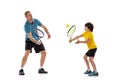 Training. Professional tennis player, coach teaches teen to play tennis isolated over white studio background. Concept Royalty Free Stock Photo